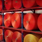 Rolls of red fabric for shade cloth.