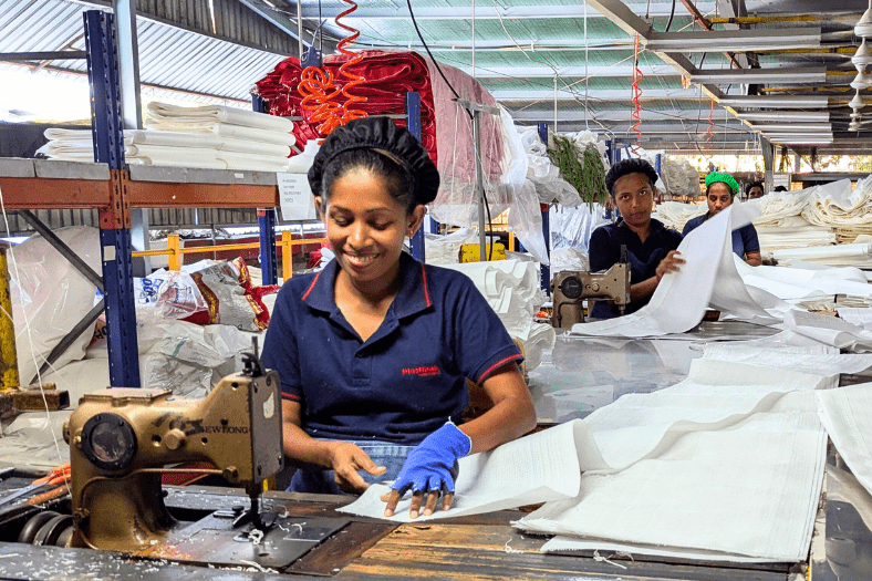 Smiling worker making woven bulk bag.
